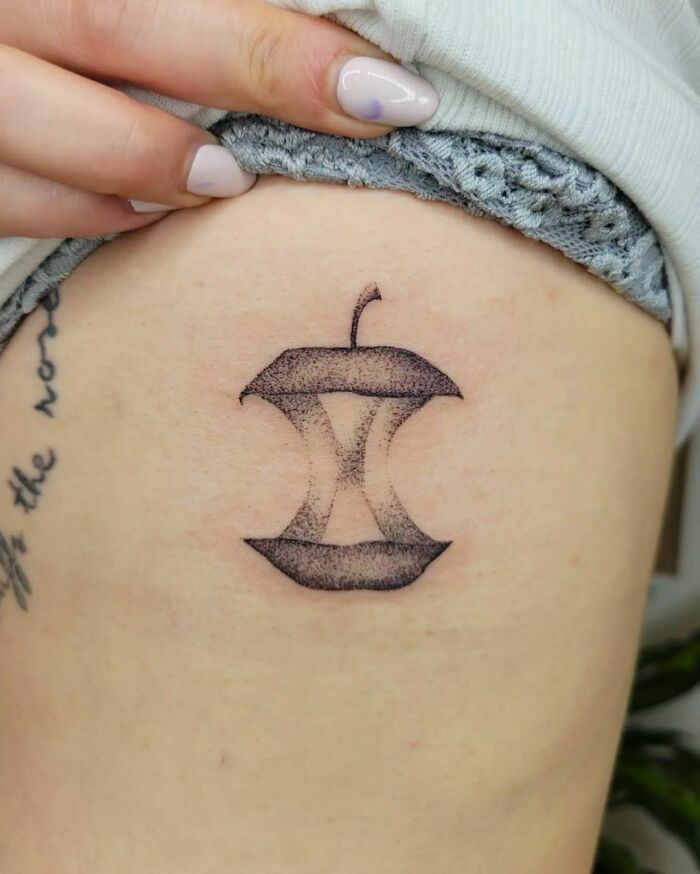 Geometric apple tattoo inked on skin, showcasing creative food tattoo art.