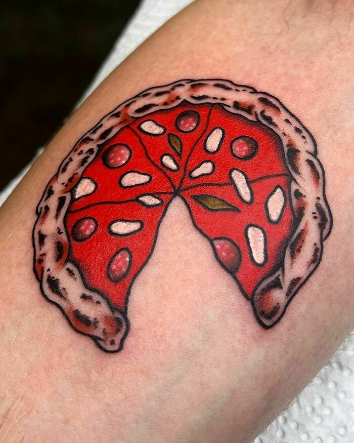 Pizza slice tattoo on forearm, showcasing vibrant red and details, perfect for food tattoo enthusiasts.