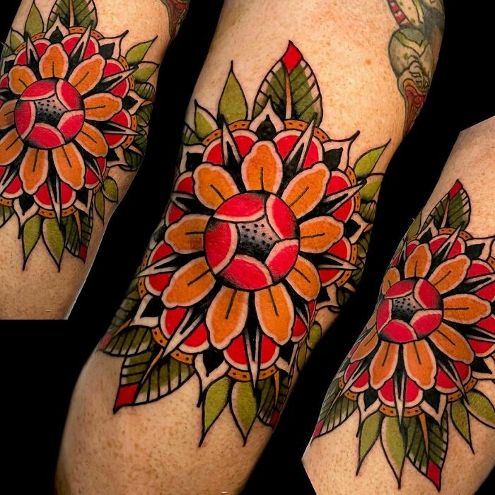 Close-up of vibrant American traditional tattoo with floral and geometric patterns on an arm.