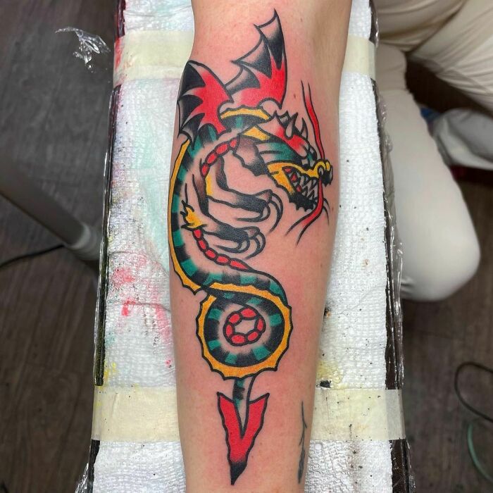 Colorful dragon American traditional tattoo design on a forearm.