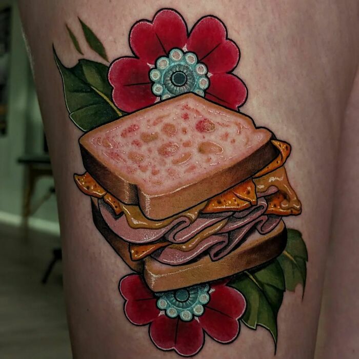 Watercolor sandwich tattoo with vibrant flowers, showcasing creative food ink-spiration.