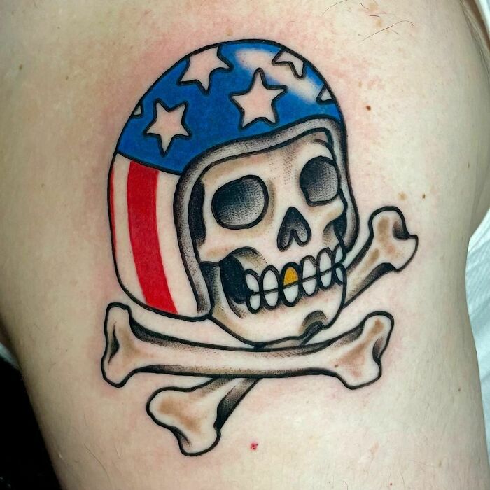American traditional tattoo of a skull and crossbones wearing a patriotic helmet.