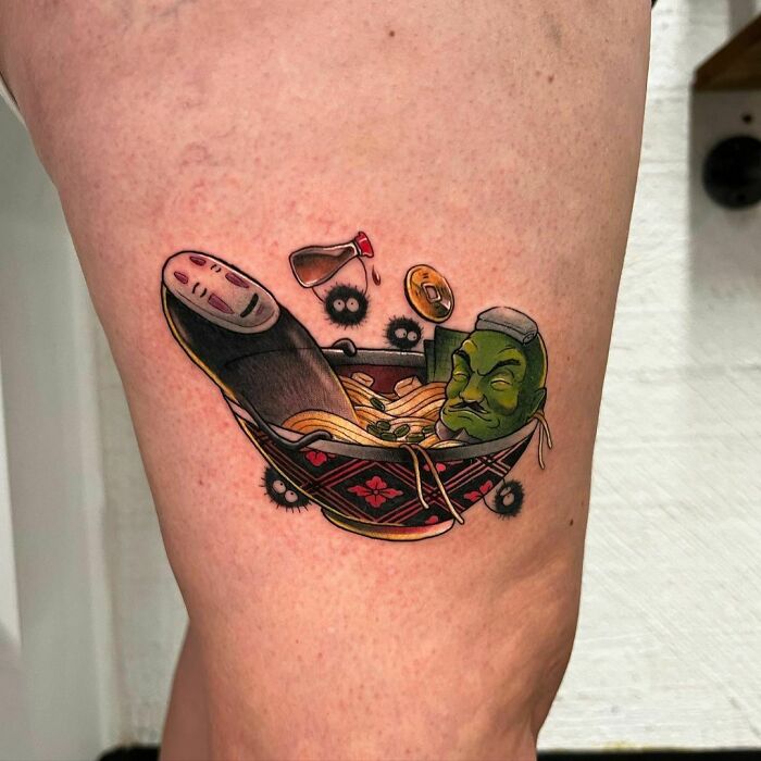 Colorful food tattoo of ramen bowl with playful characters and sauce bottle, showcasing unique and delicious food art.