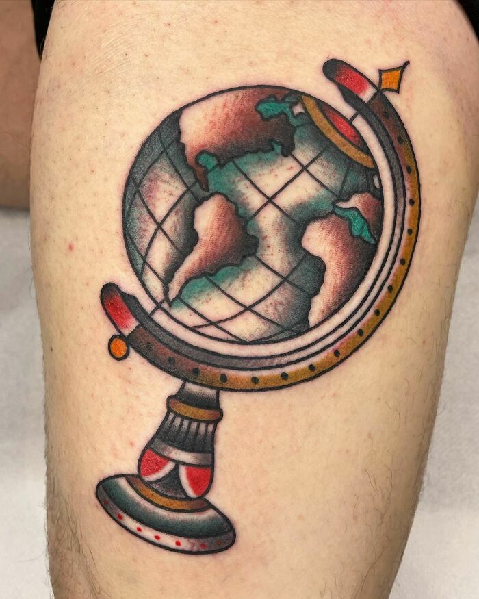 American traditional tattoo featuring a colorful globe design on skin.