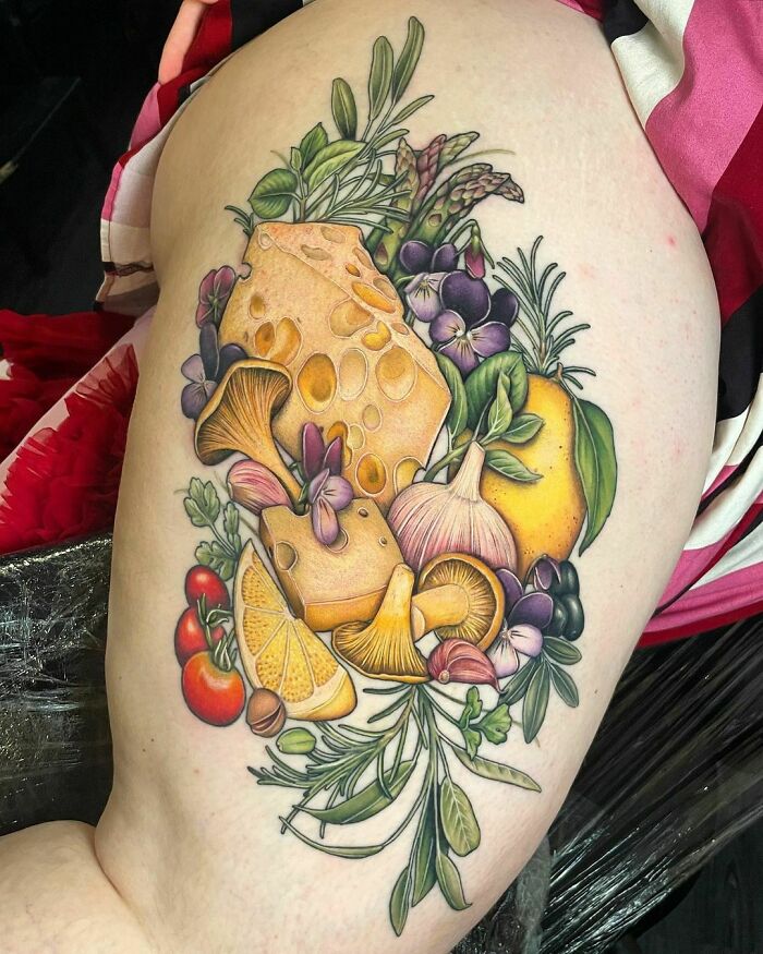 Watercolor vegetables tattoo featuring vibrant herbs and cheese on an arm, showcasing food tattoo inspiration.