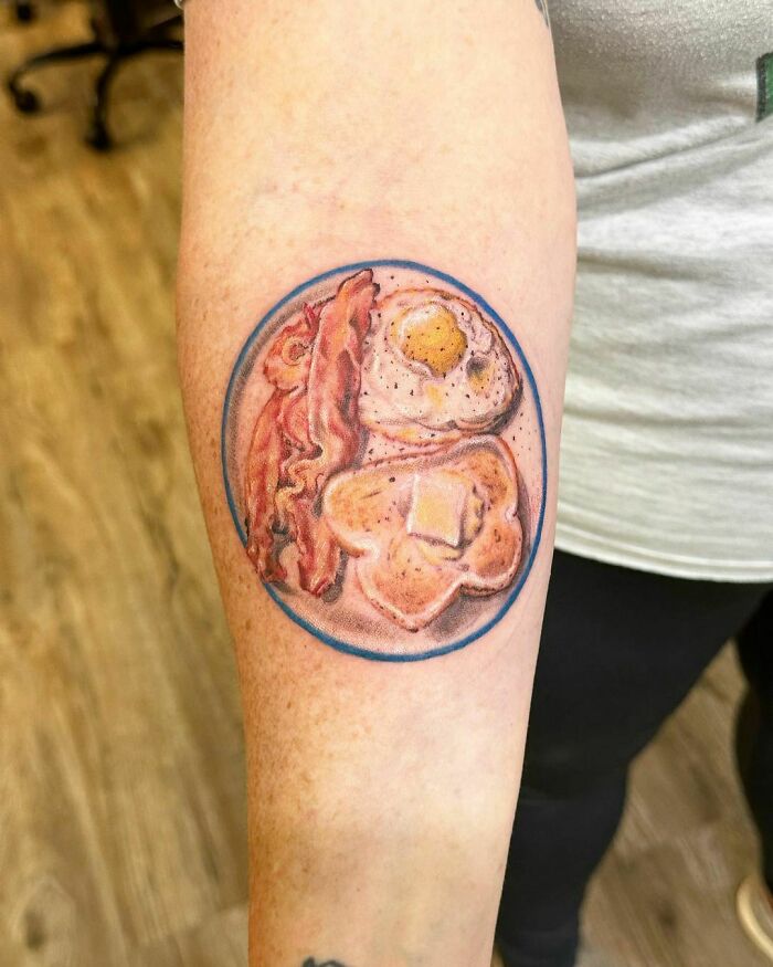 Watercolor tattoo of eggs and bacon plate, showcasing a creative food tattoo design.