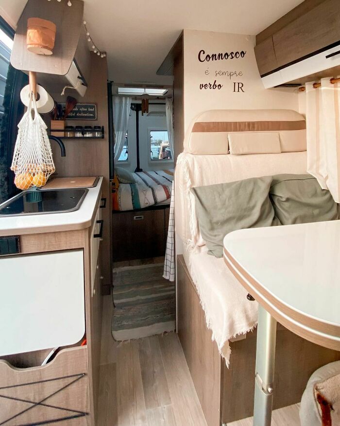 Cozy tiny house interior with kitchen, dining, and bedroom area in compact space.