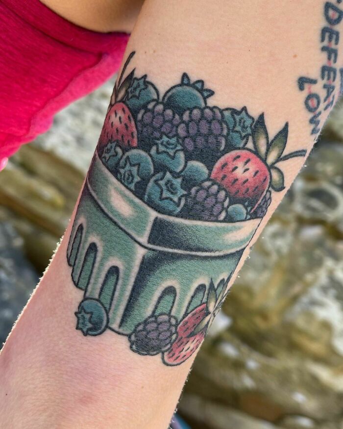 Wild berries watercolor tattoo on skin, showcasing vibrant fruity design for food ink-spiration.