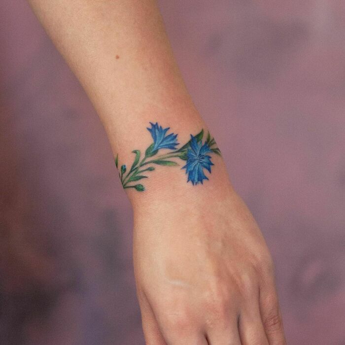 Blue floral wrist tattoo design.