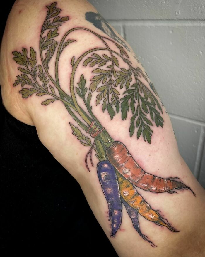 Colorful carrots watercolor tattoo on arm, showcasing vibrant food ink-spiration.