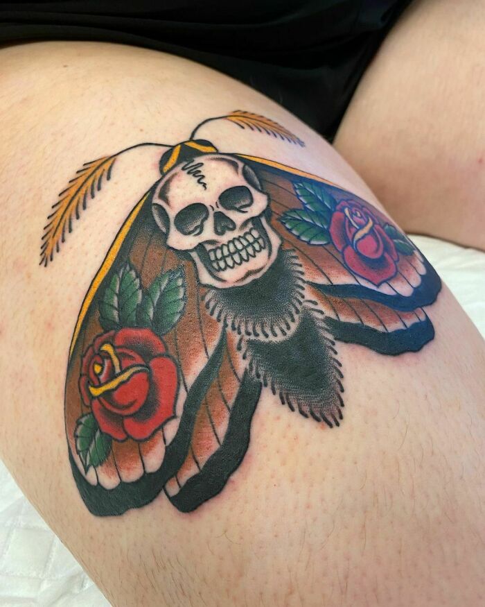 American traditional tattoo of a skull and roses on thigh, showcasing timeless design and style.