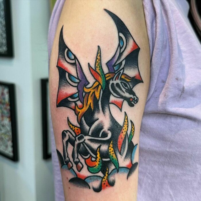 American traditional tattoo featuring a colorful winged horse on an arm.