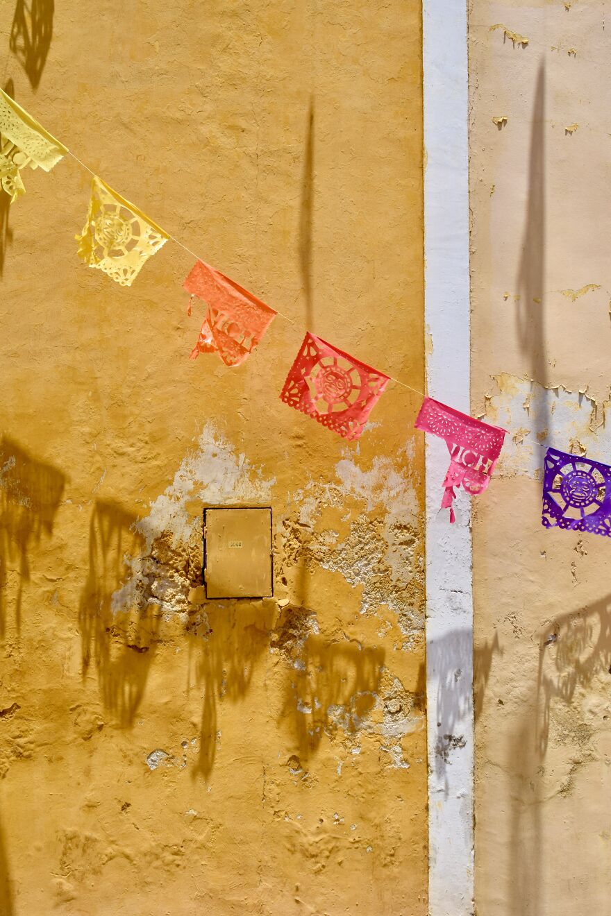 Papel Picado Against A Yellow Wall In Izamal, Yucatan