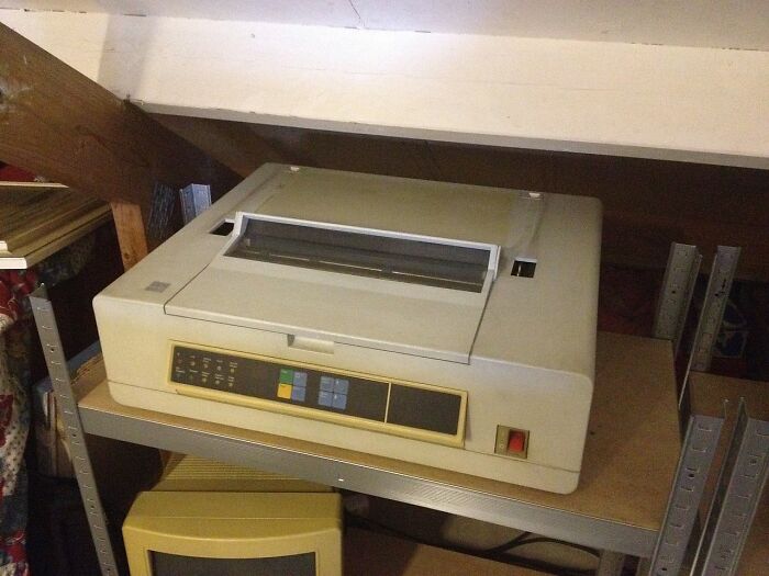 Vintage old gadget printer on a metal shelf showcasing classic technology from trendsetters of their time.