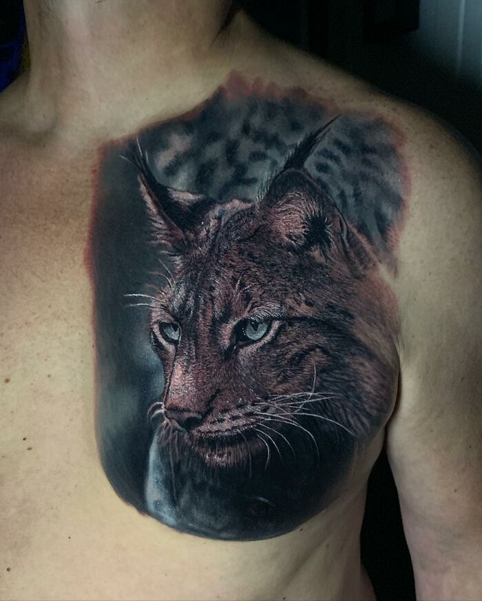 Detailed lynx tattoo art on chest, showcasing intricate shading and realism.