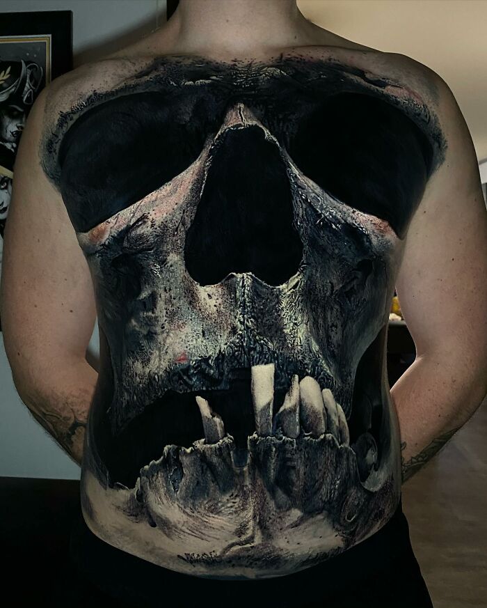 Innovative tattoo art of a detailed skull design covering a person's torso.