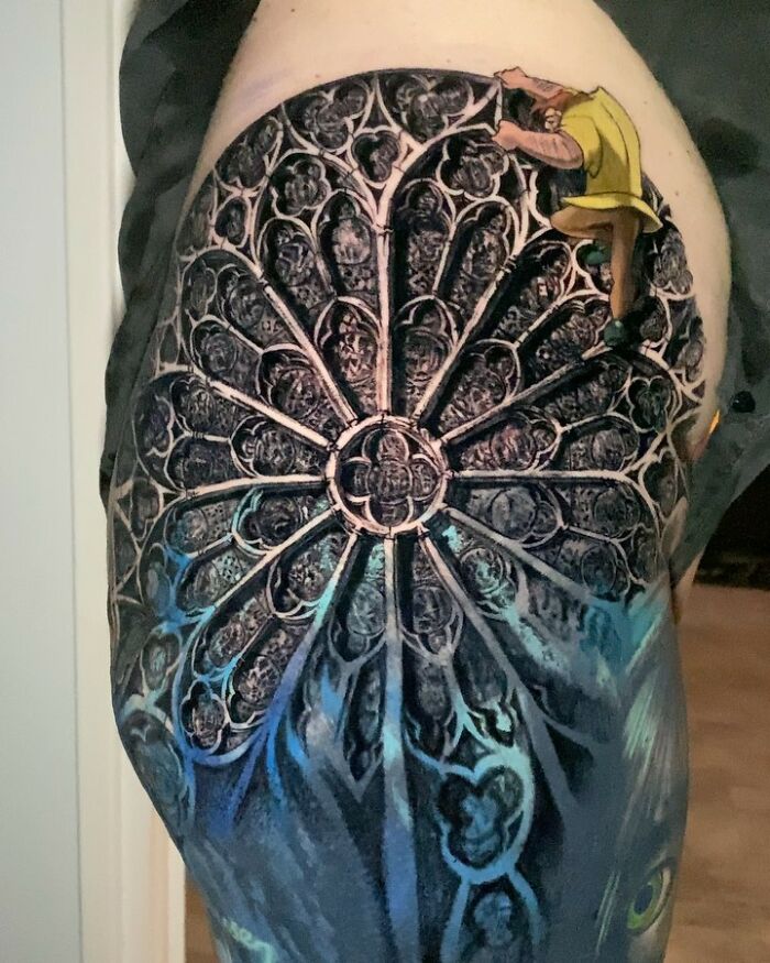 Tattoo art depicting a detailed stained glass design with a vibrant color palette and intricate patterns.