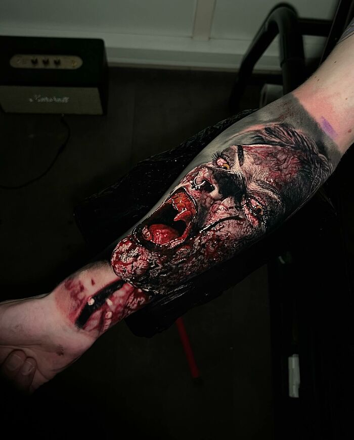 Forearm tattoo art depicting a hyper-realistic, detailed face with expression and intricate textures.
