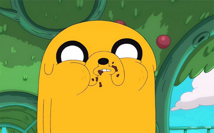 Jake the Dog eating chocolate with a messy face, showcasing a wacky moment from Adventure Time quotes and scenes.