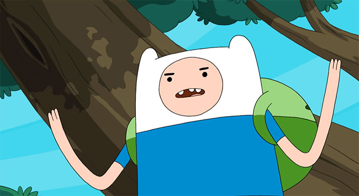 Finn the Human from Adventure Time arguing with arms raised in front of a tree with blue sky background.