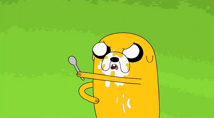 Jake the Dog from Adventure Time with his face covered in melting ice cream holding a spoon against a green background
