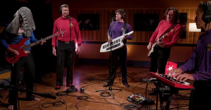 Multiple men playing instruments and singing 