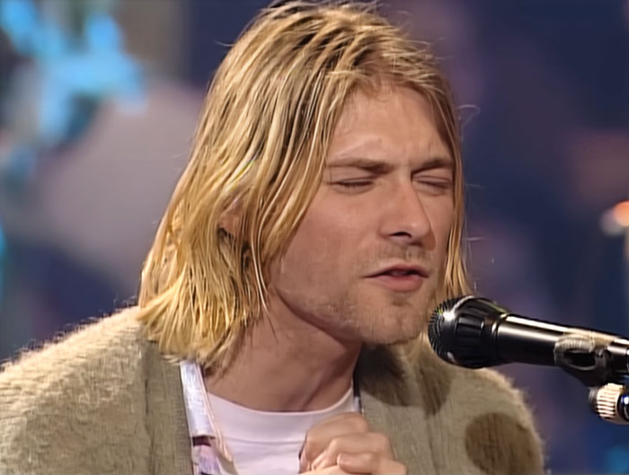 Man sitting and singing into the microphone 