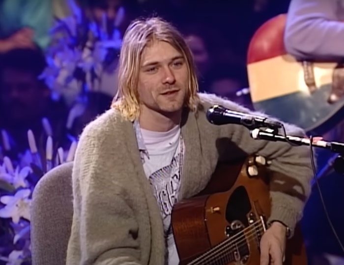 Person Sitting and playing a guitar 