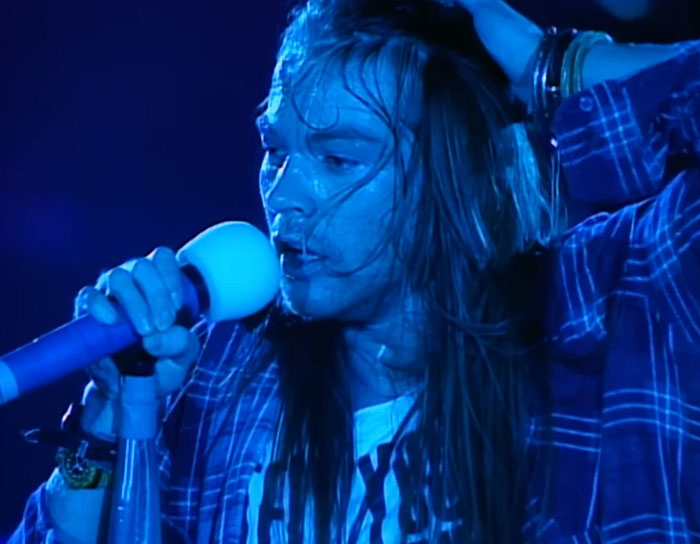 Man singing into the microphone while being wet 