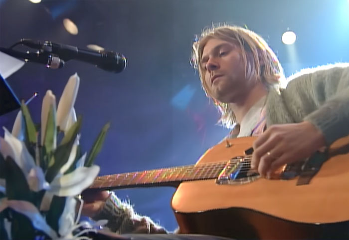 Person sitting and playing with a guitar 