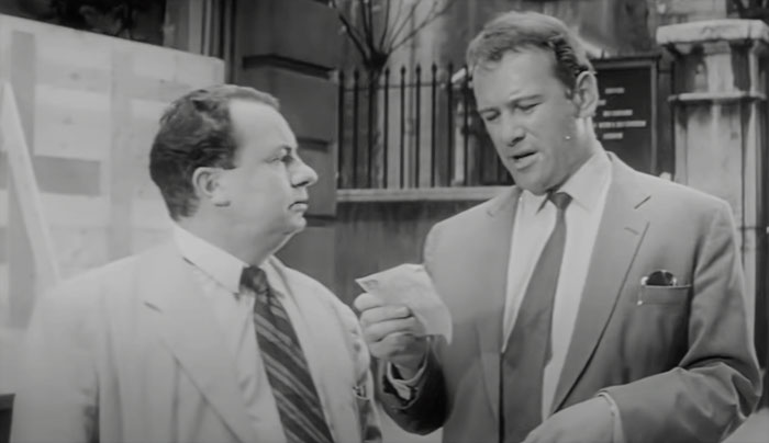 Petter holding piece of paper and talking with Bill