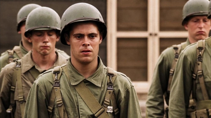 Multiple men with soldier outfits standing 