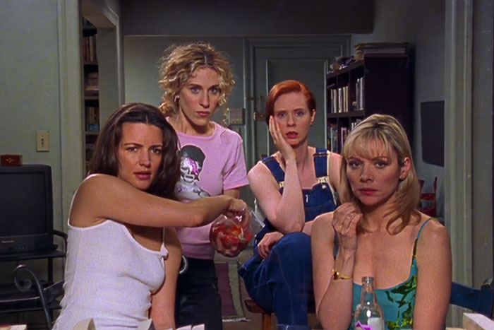 Four woman watching at something and eating 