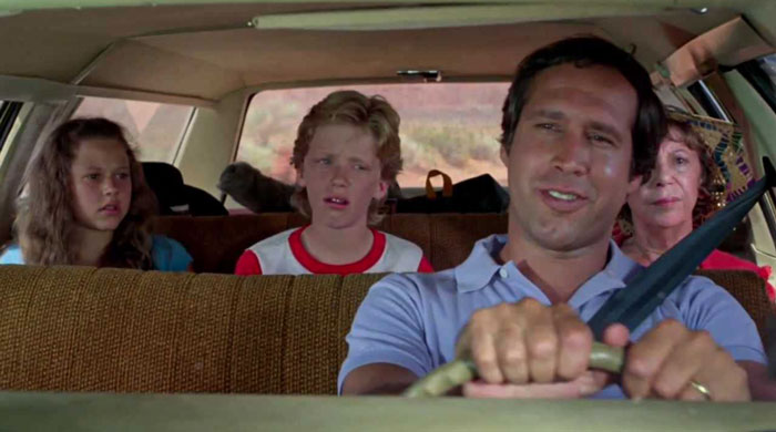 Clark Griswold driving and talking with kids from National Lampoon’s franchise