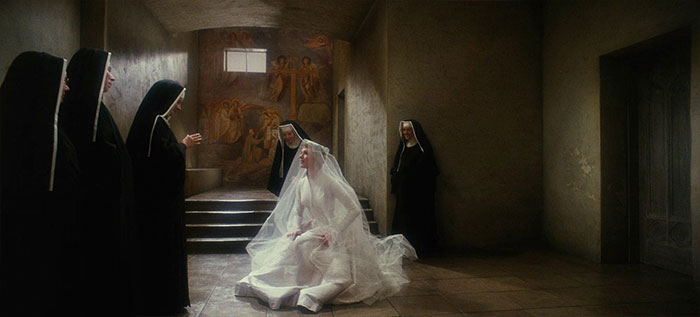 Bride in a wedding dress surrounded by nuns in a dimly lit scene from a classic wedding movie celebrating love.