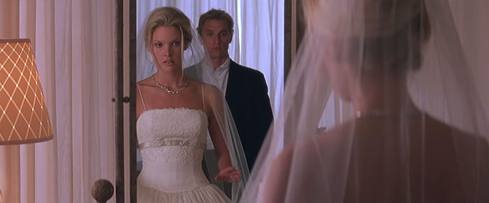 Scene from The Wedding Planner movie showing a bride in a wedding dress reflected in a mirror, celebrating love in wedding movies.
