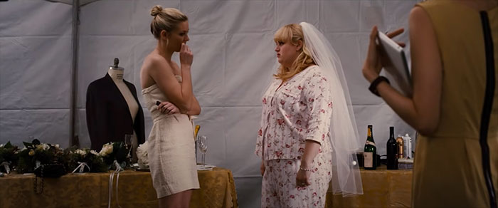 Scene from Bachelorette movie showing two women, one in a towel and the other in a bridal veil, celebrating wedding movie moments.