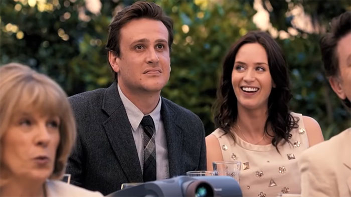 Couple sharing a moment at an outdoor event in a scene from The Five-Year Engagement, wedding movies celebrating love.