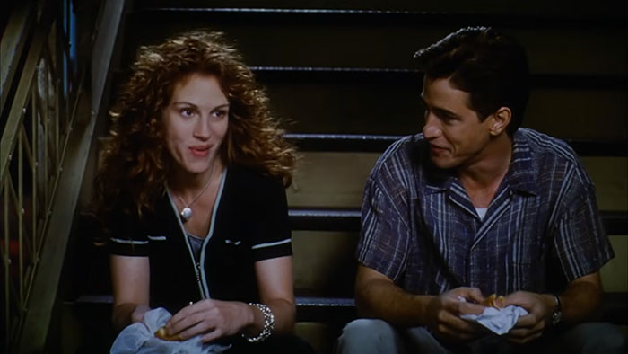 Scene from a wedding movie featuring two characters sitting on stairs, highlighting the best wedding movies ever made.