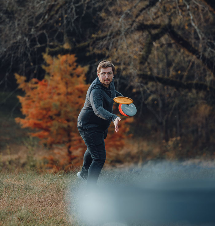 Man throwing three Frisbees at once 