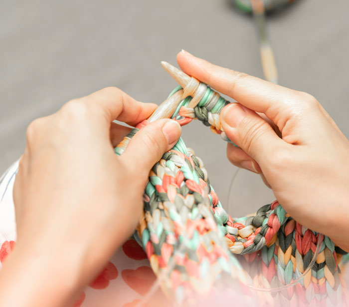 Person knitting a colorful clothes 