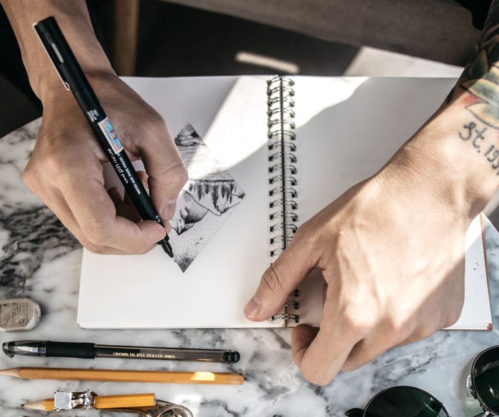 Mat drawing sketches into a book 