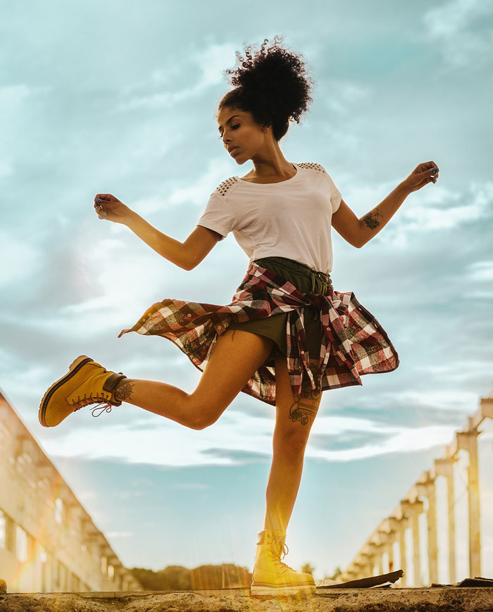 Woman dancing in the sun on the bridge 