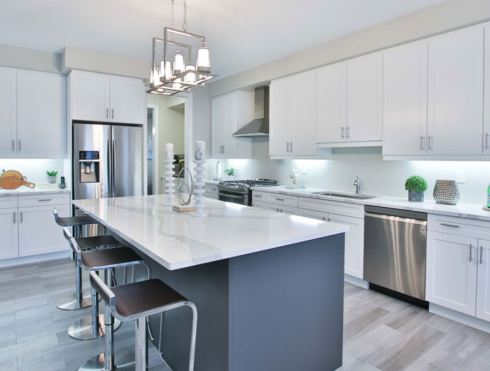 a big kitchen island opposite white cabinets