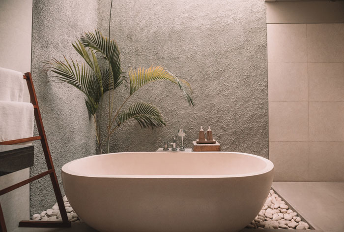 the bath standing on a white stones near a grey wall