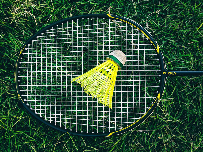 a yellow shuttlecock lying on the racket