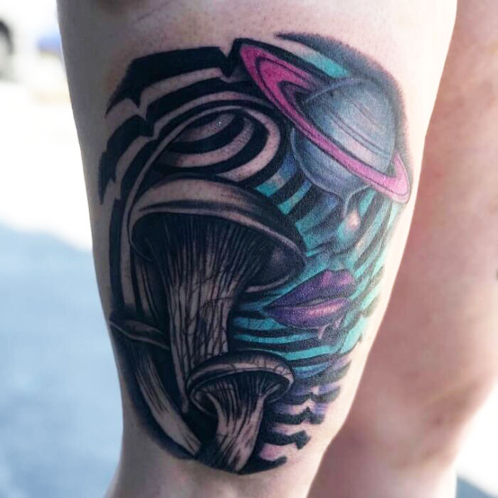 Optical illusion tattoo featuring abstract mushrooms and a colorful planet-like design.