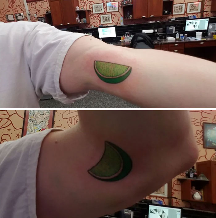 Green lime slice food tattoo on an arm in a tattoo studio setting.