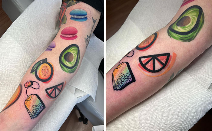 Colorful food tattoos featuring avocados, macarons, and citrus slices on forearm.