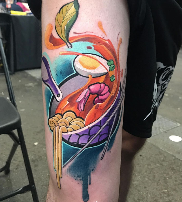 Colorful food tattoo featuring ramen, shrimp, and a leaf on an arm.